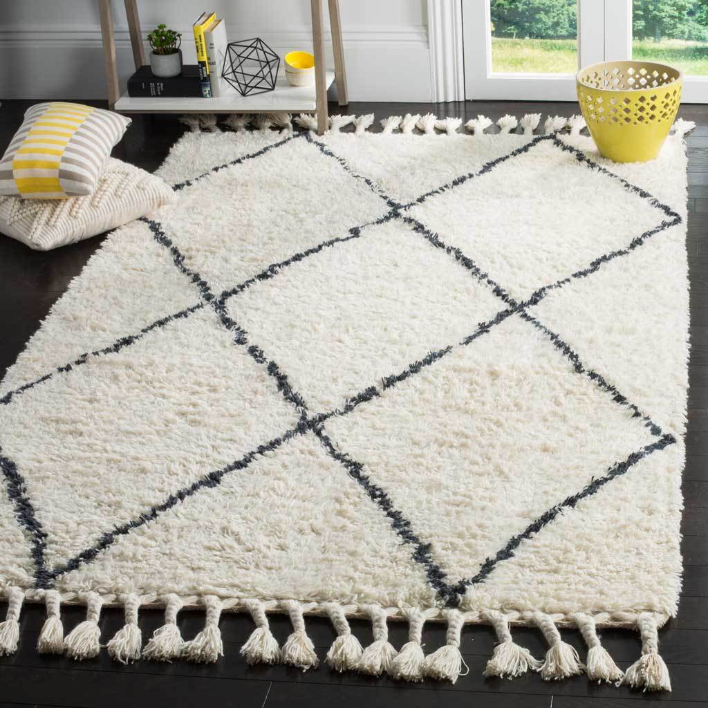 An ivory shag rug with dark gray diamonds and long tassels softens a bright living space.