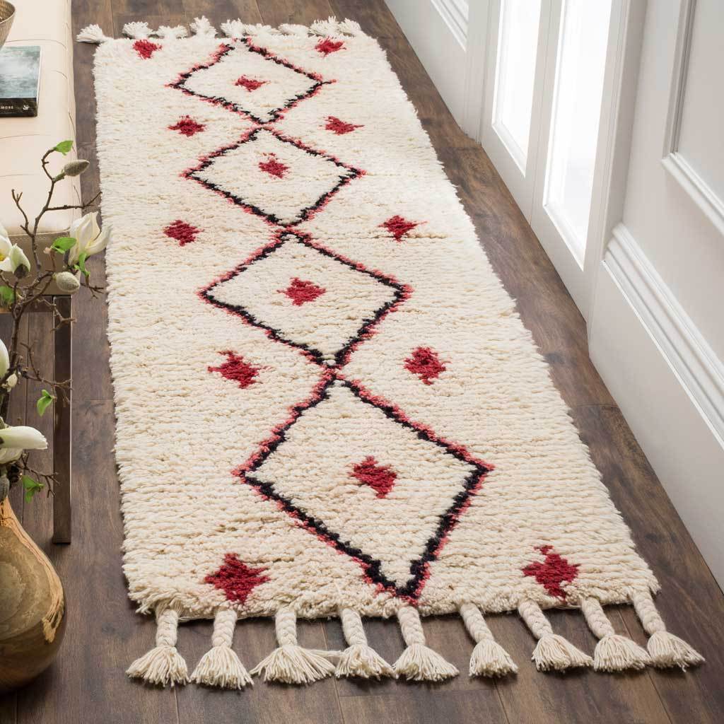 Plush ivory pile and bold geometric motifs bring warmth and color to this tasseled runner rug
