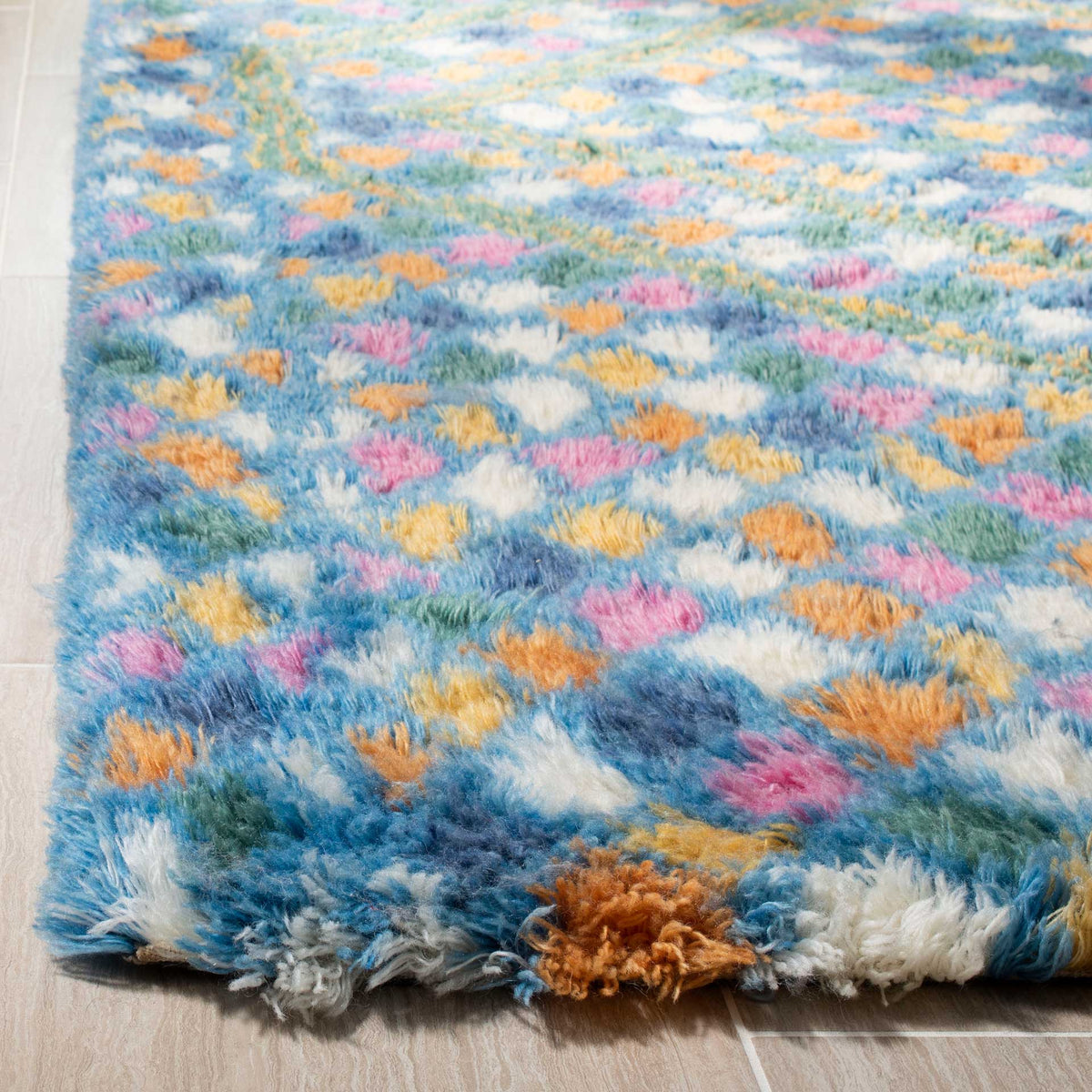 Thick, shaggy pile mixes soft blue and ivory with lively pink and orange tufts