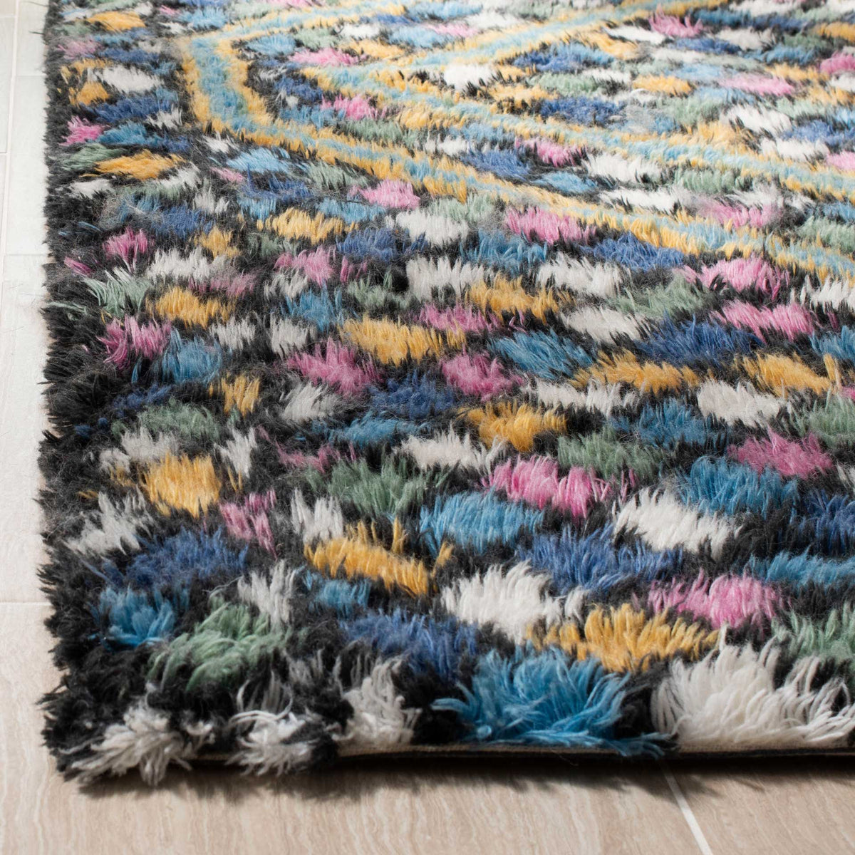 Thick, fluffy pile blends blue, gold, pink, green, and ivory yarns along a plush edge