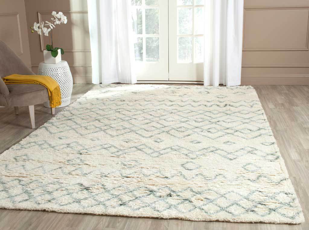 Ivory and blue patterned rug lends cozy texture to a light-filled living room