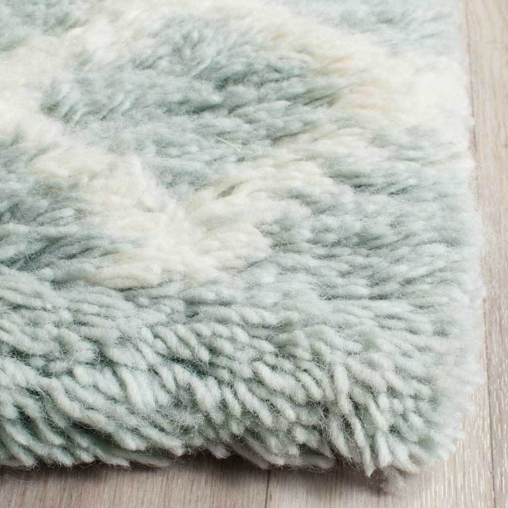 Thick wool pile blends powder blue and ivory fibers for a soft, inviting edge