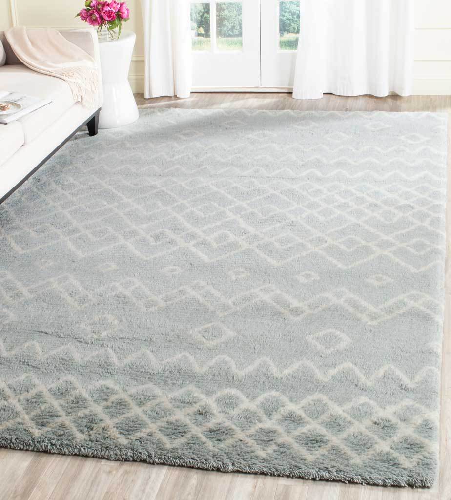 Blue geometric rug grounds a bright living space with plush texture and ivory diamond motifs