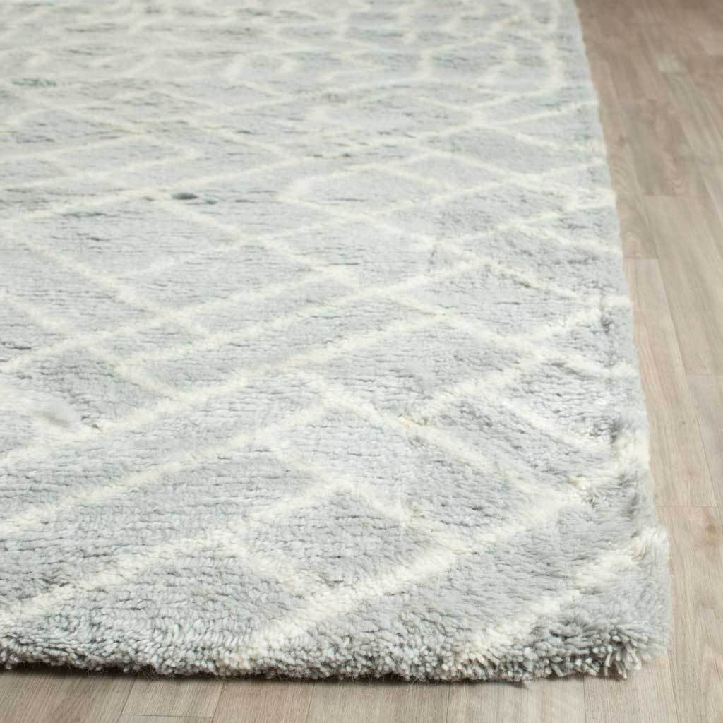 Raised ivory lines cross the plush blue pile and textured corner