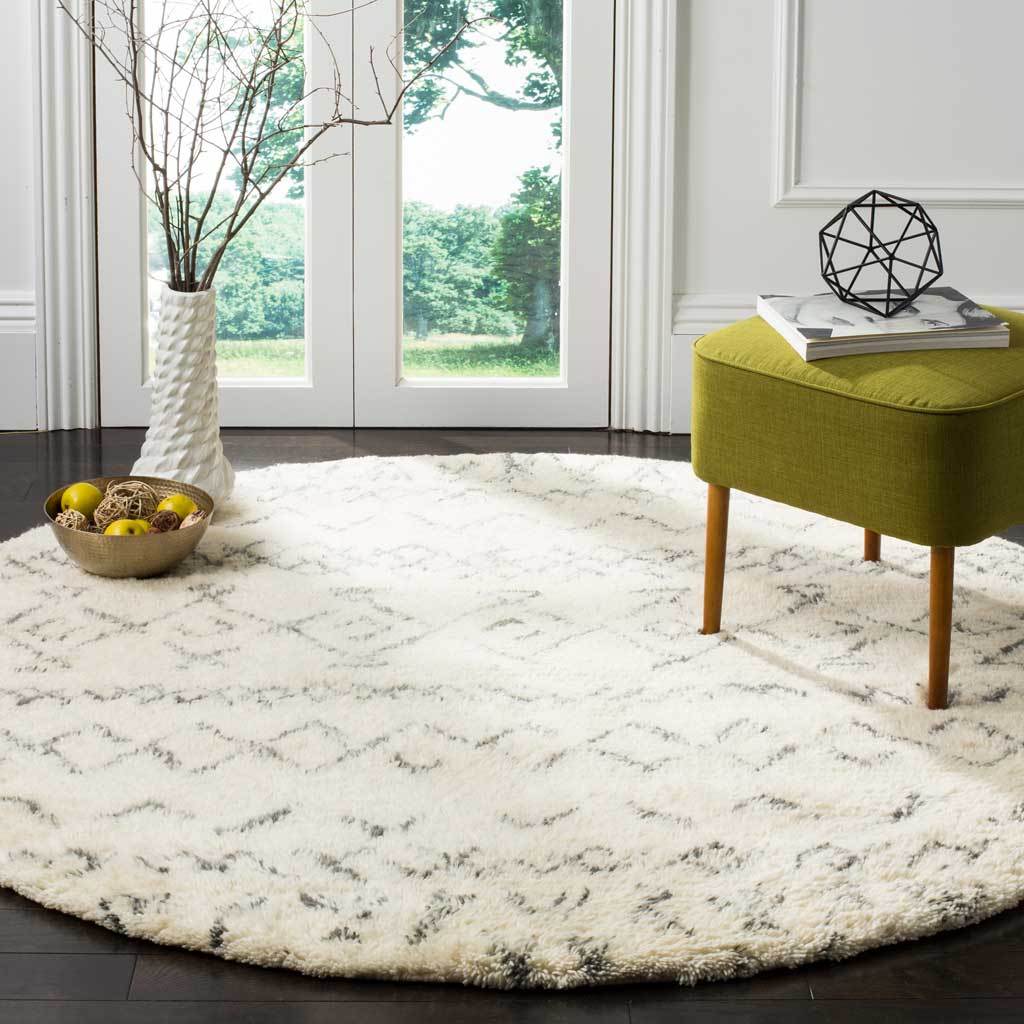 Ivory geometric shag rug softens a bright space with a green upholstered ottoman