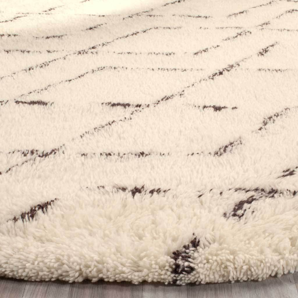 Thick ivory pile and broken brown accents create inviting texture and depth