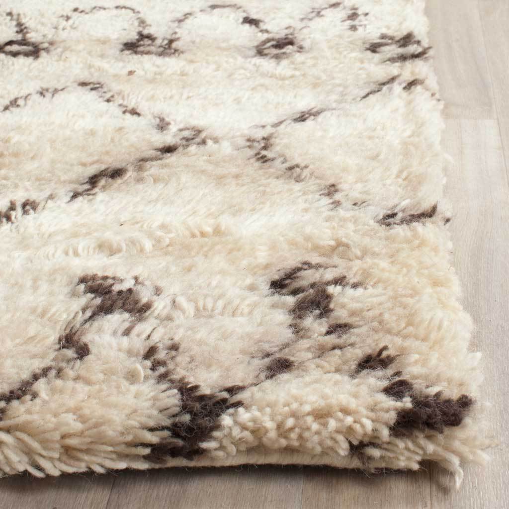Thick ivory tufts and dark brown accents highlight the rug's soft, cushioned edge.