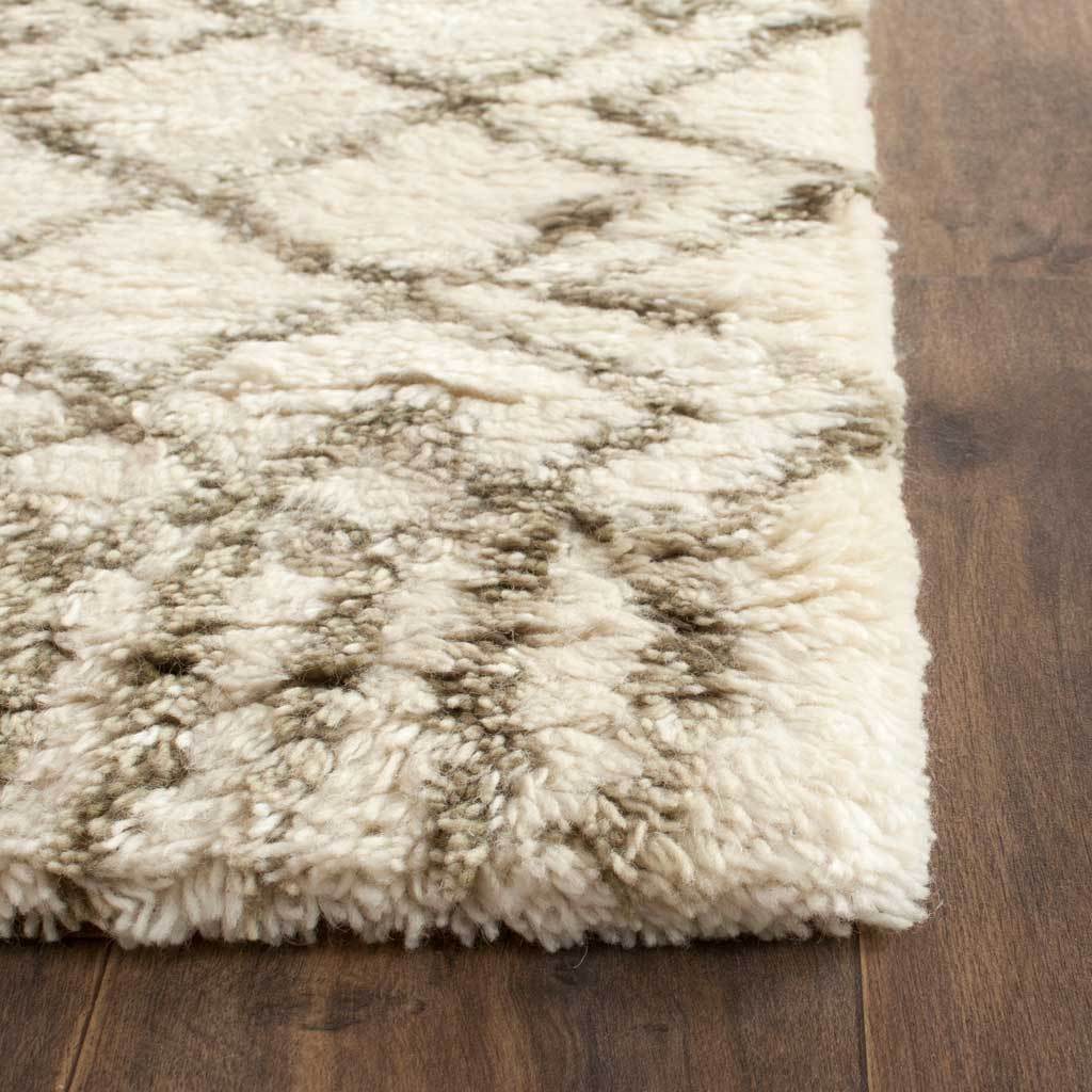 Soft wool-blend shag pile adds depth to the runner's ivory and muted green pattern.