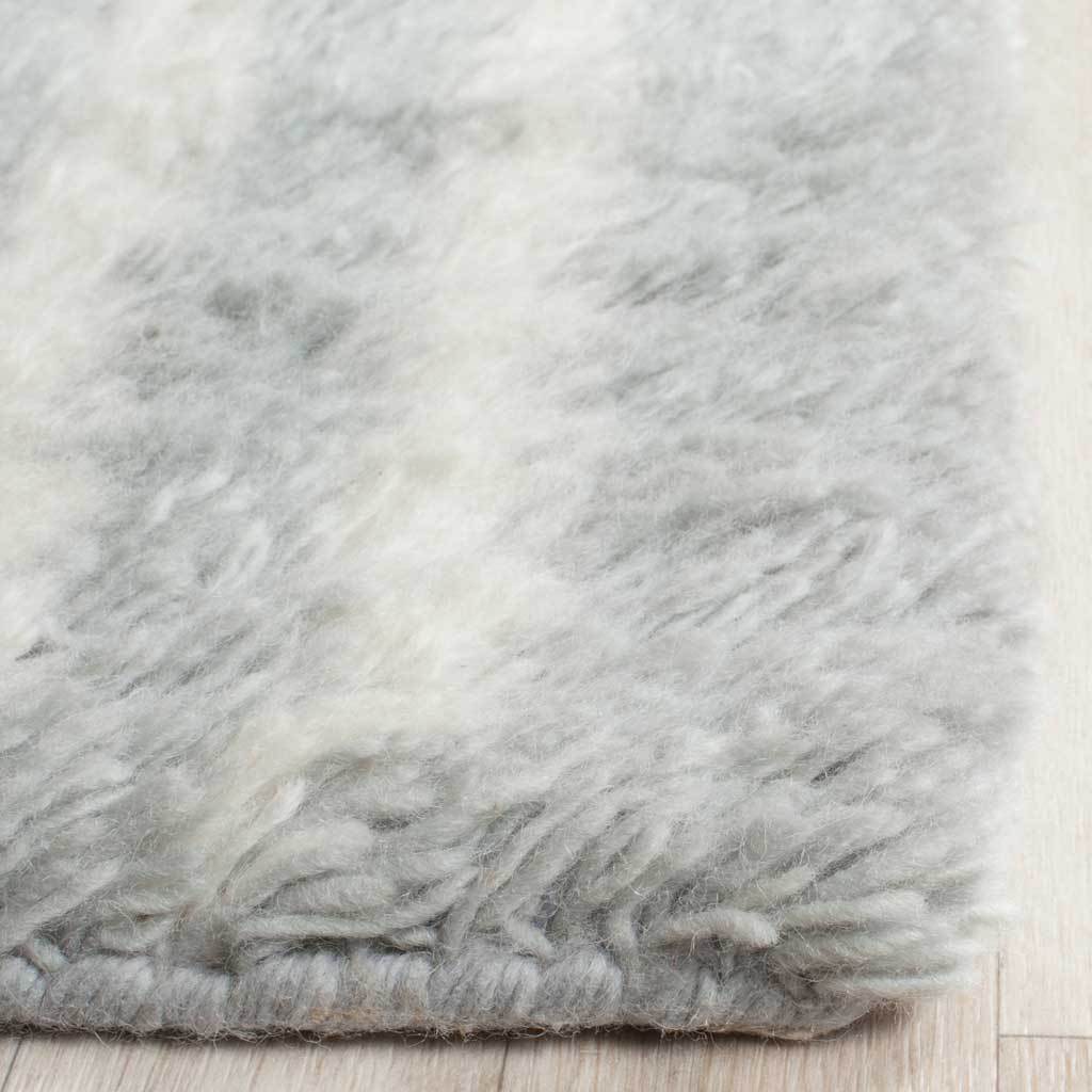 Fluffy blue-and-ivory pile and a plush finished edge add tactile appeal