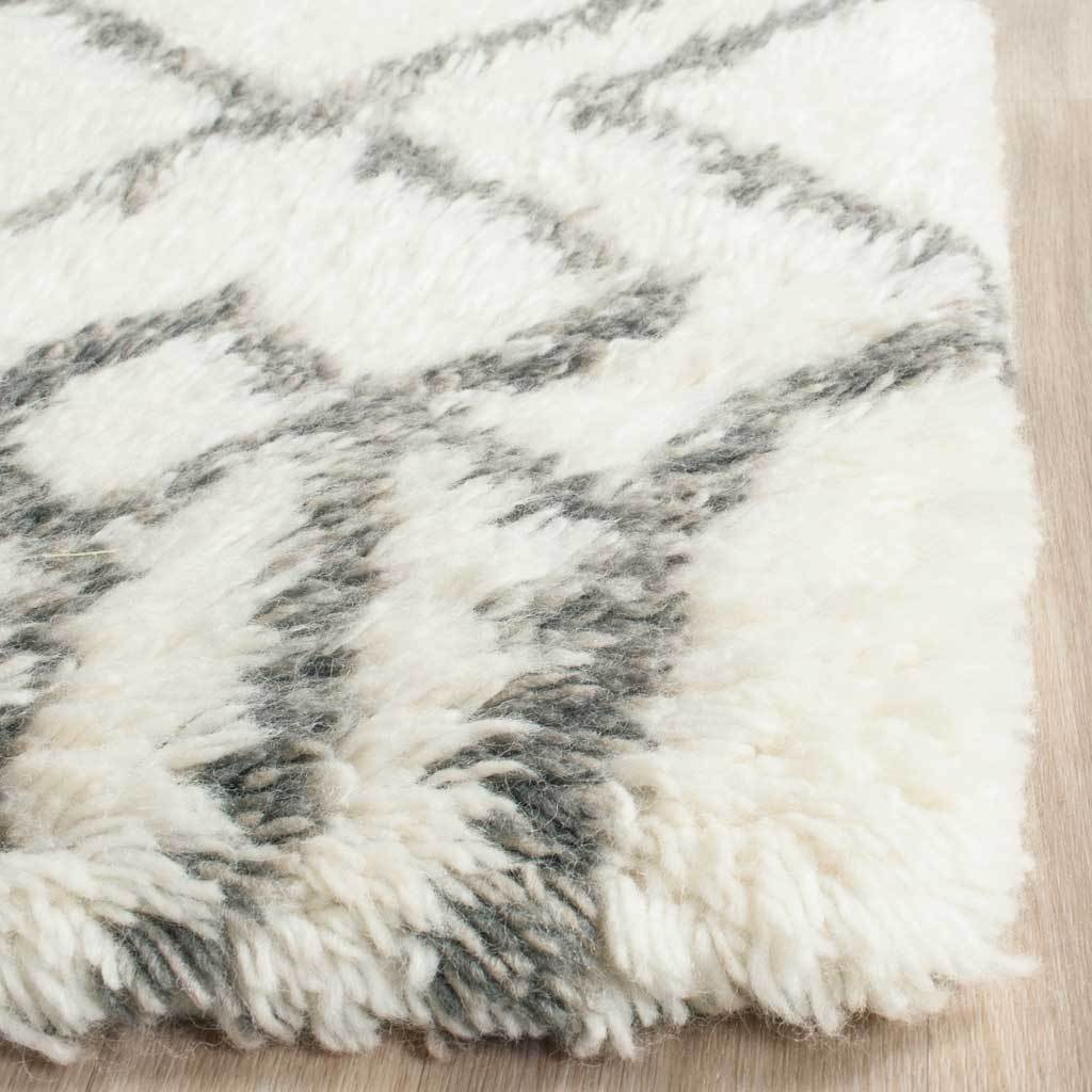 Long ivory pile frames gray lines at a soft, full rug corner