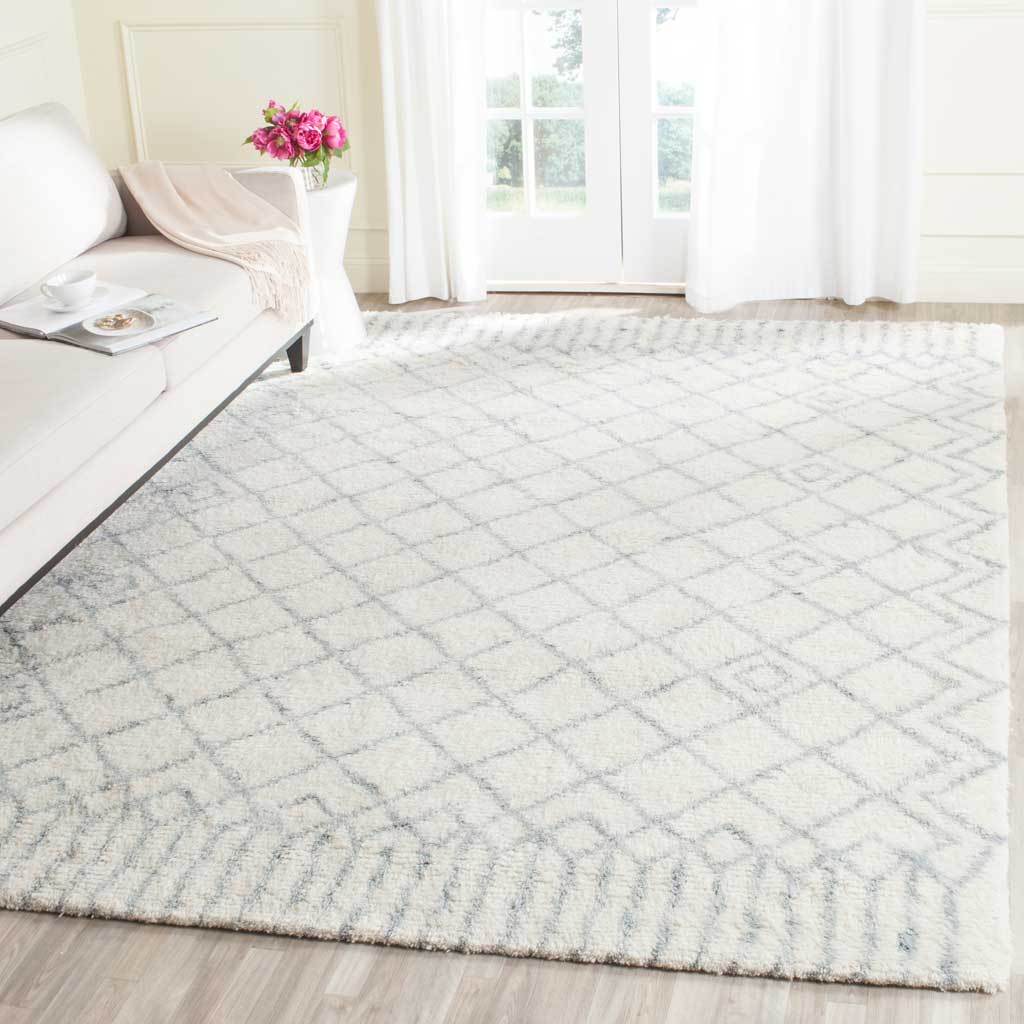 Ivory shag rug with a subtle blue diamond grid adds warmth beside a sofa