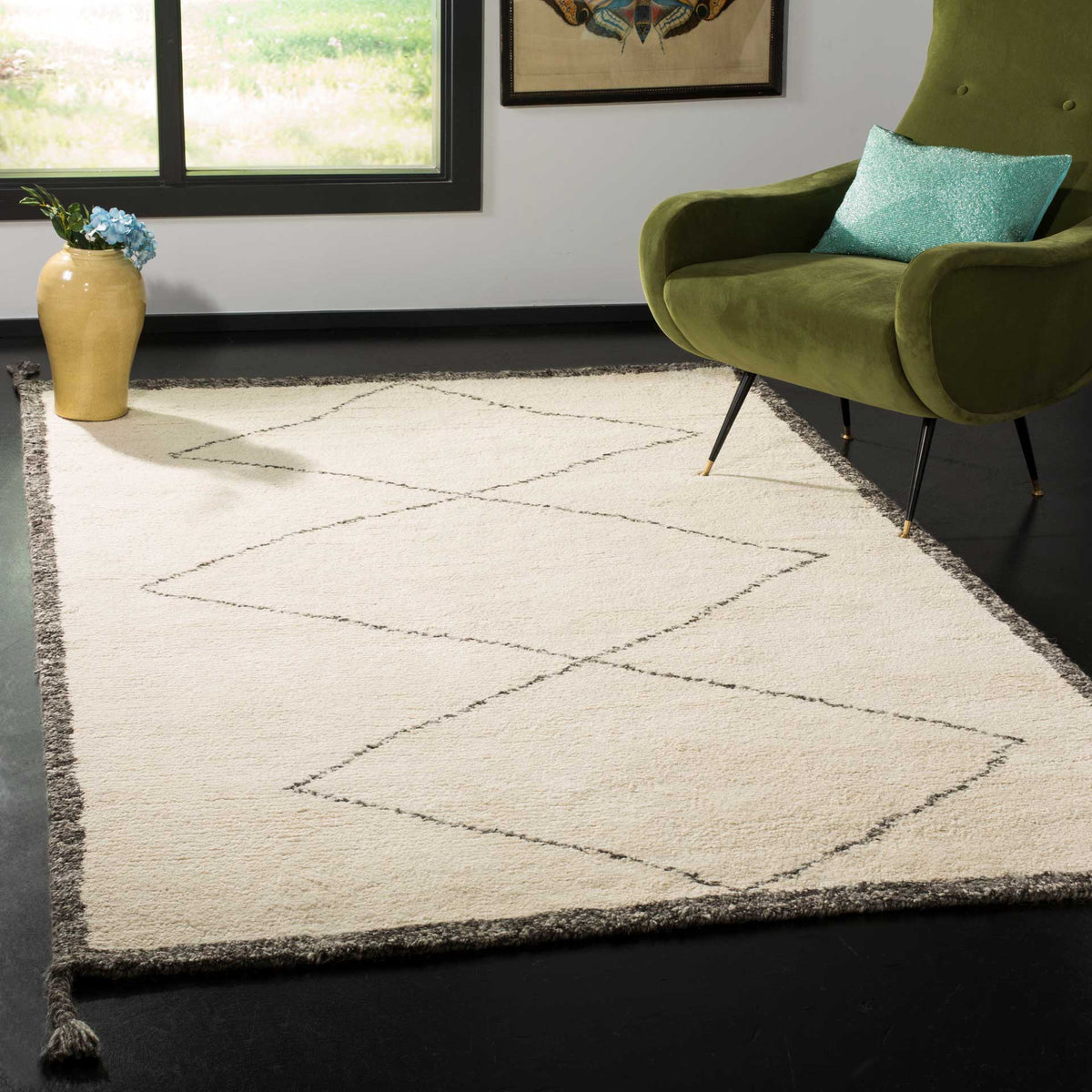 An ivory wool rug with charcoal diamond motifs and tasseled corners warms a seating area