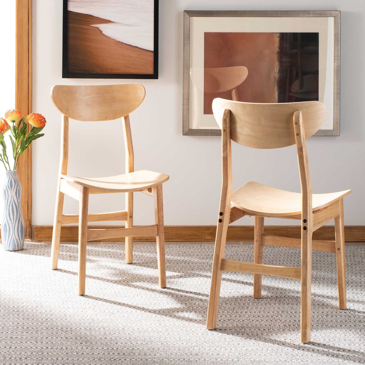 A pair of light wood chairs brings curved backs and sculpted seats to an airy room