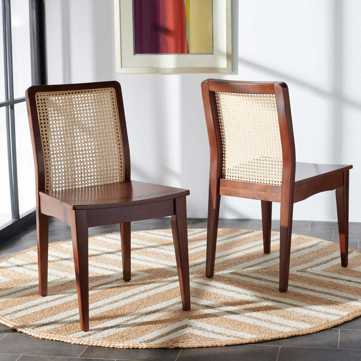 Two dark brown wood chairs bring breezy rattan backs and warm tones to a dining area