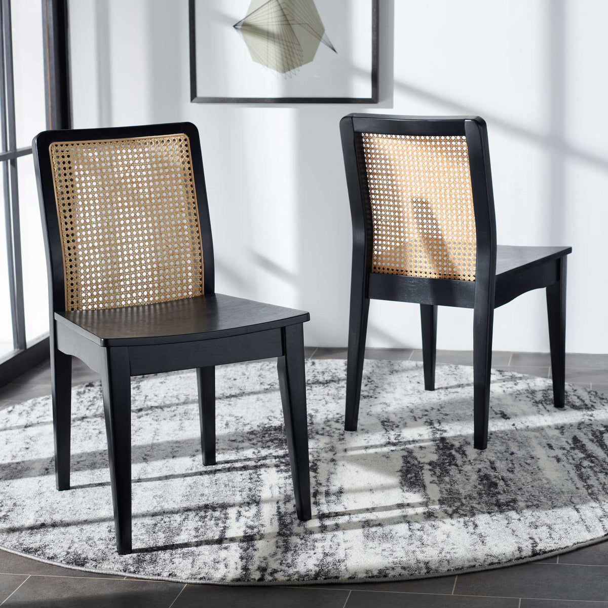 A pair of black wood chairs brings airy cane backs and clean lines to a dining space