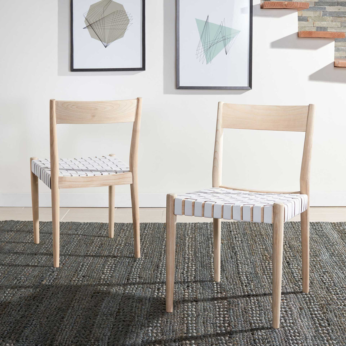 Two light wood dining chairs with white woven leather seats create a bright dining area