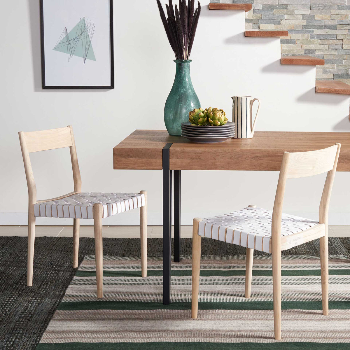 White basket-woven leather seats and pale wood frames lend an airy feel beside the dining table