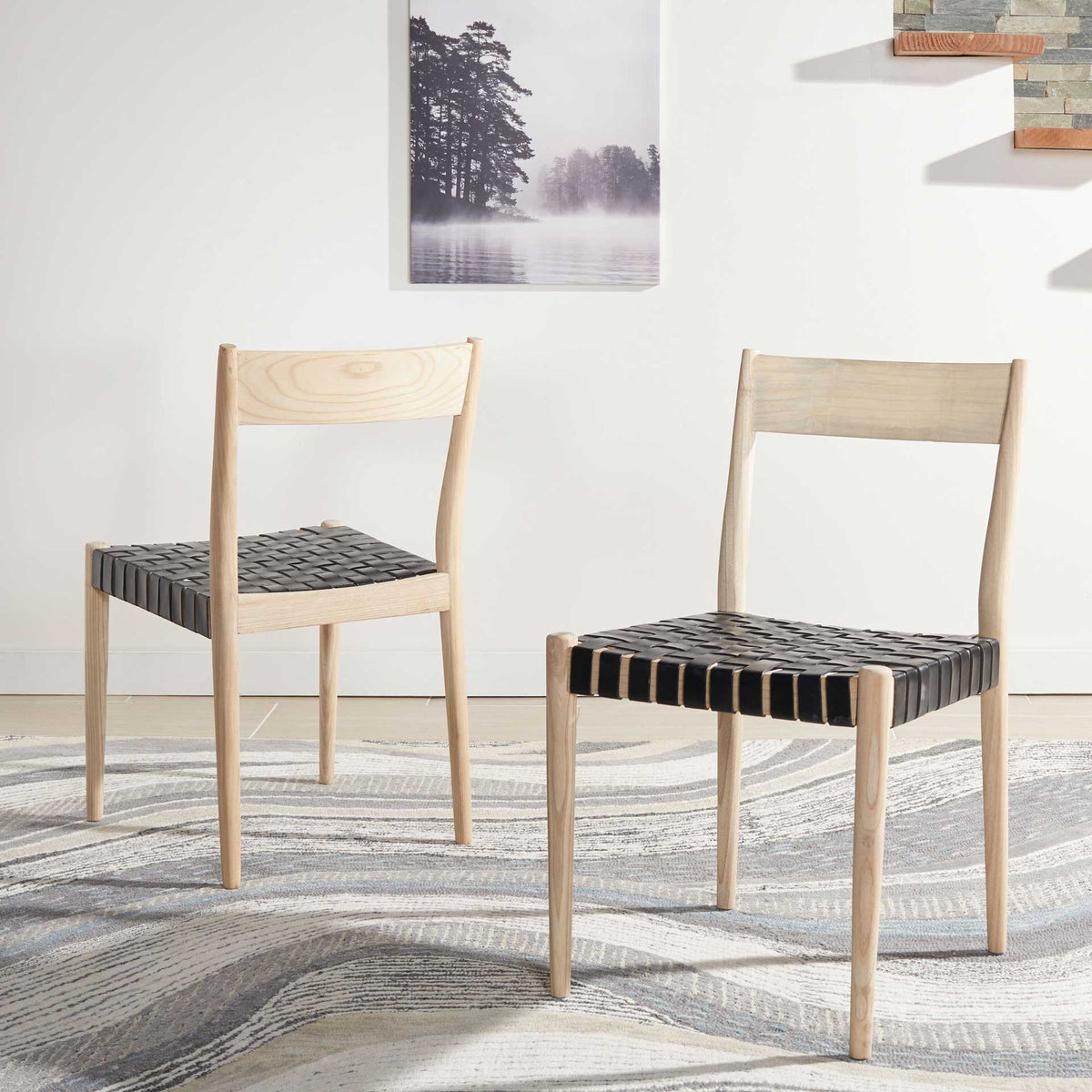 Two natural wood chairs bring black woven leather seats and an airy feel to a dining area
