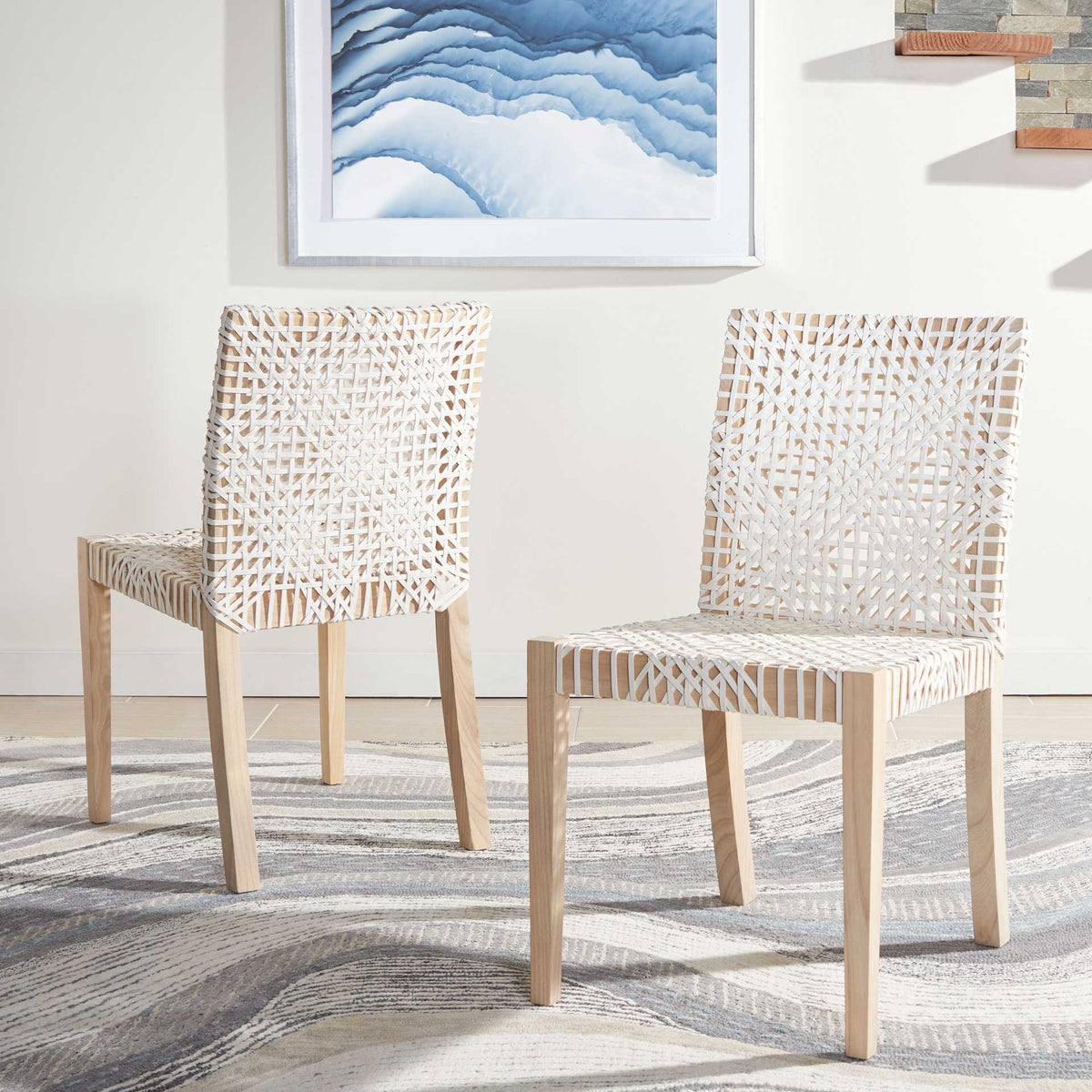 A pair of woven white leather chairs adds airy texture and natural teak warmth to a bright room
