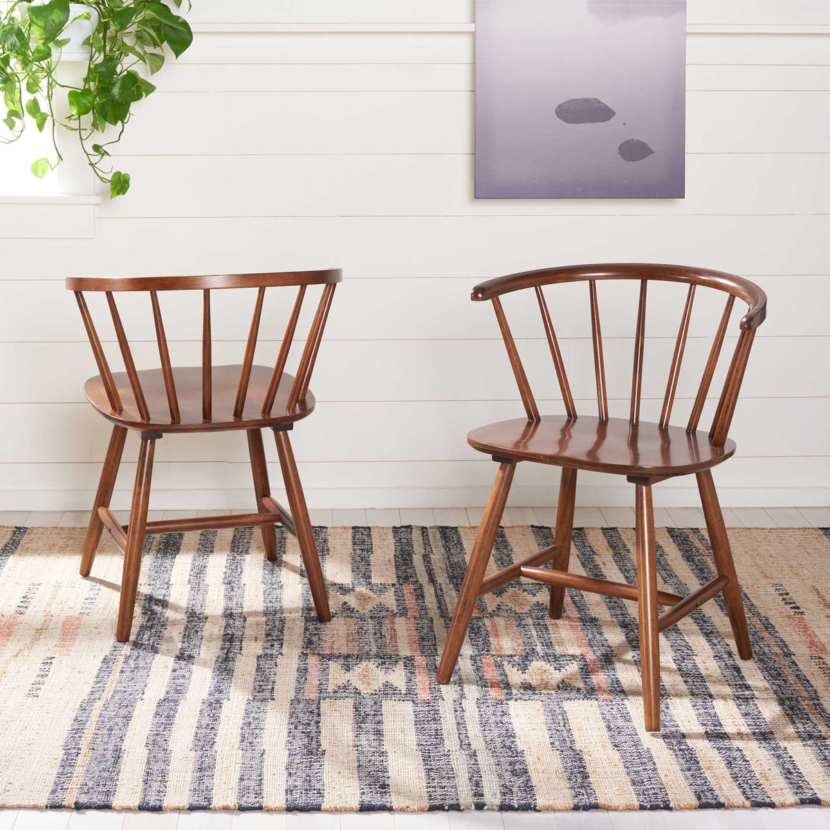 Two walnut-finished spindle-back chairs bring warmth to a bright room with a patterned rug