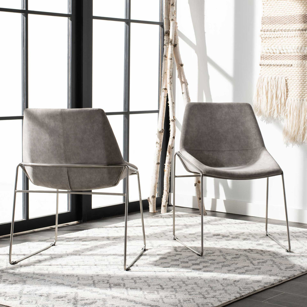 Matching stone gray chairs feature curved seats and airy silver frames