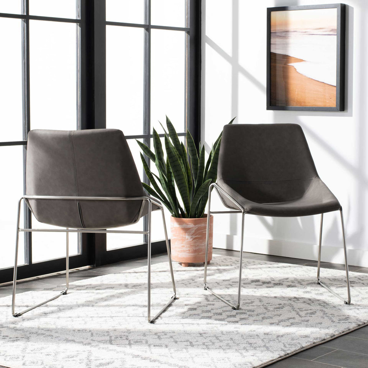 A matching ash gray chair pair highlights softly curved seating and gleaming silver sled bases