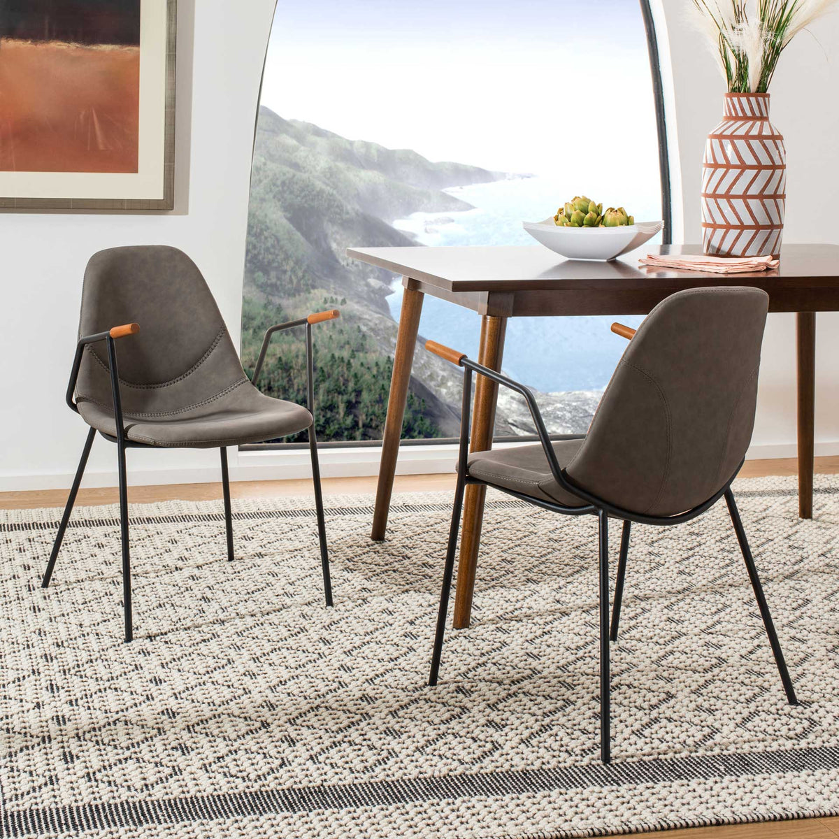 Ash gray chairs pair wood-tone arm caps with graceful black metal legs for an inviting dining space