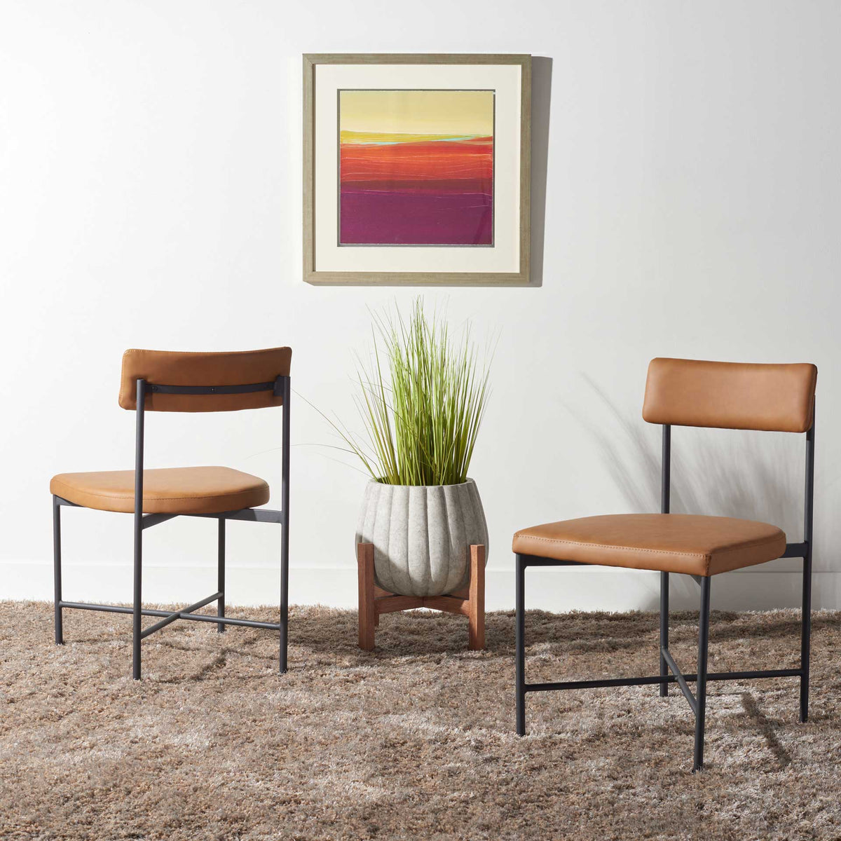 Warm cognac seats and airy black frames give these dining chairs an inviting midcentury feel