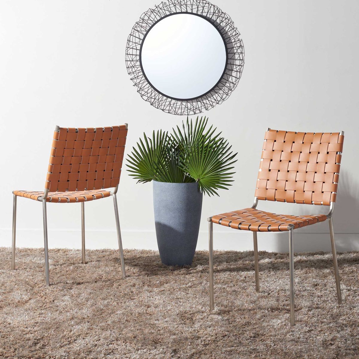 Cognac woven leather and silver metal lend this dining chair pair a warm, airy feel