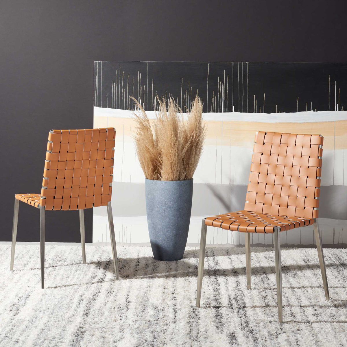 A pair of cognac woven chairs adds warm texture and crisp silver accents to the room.