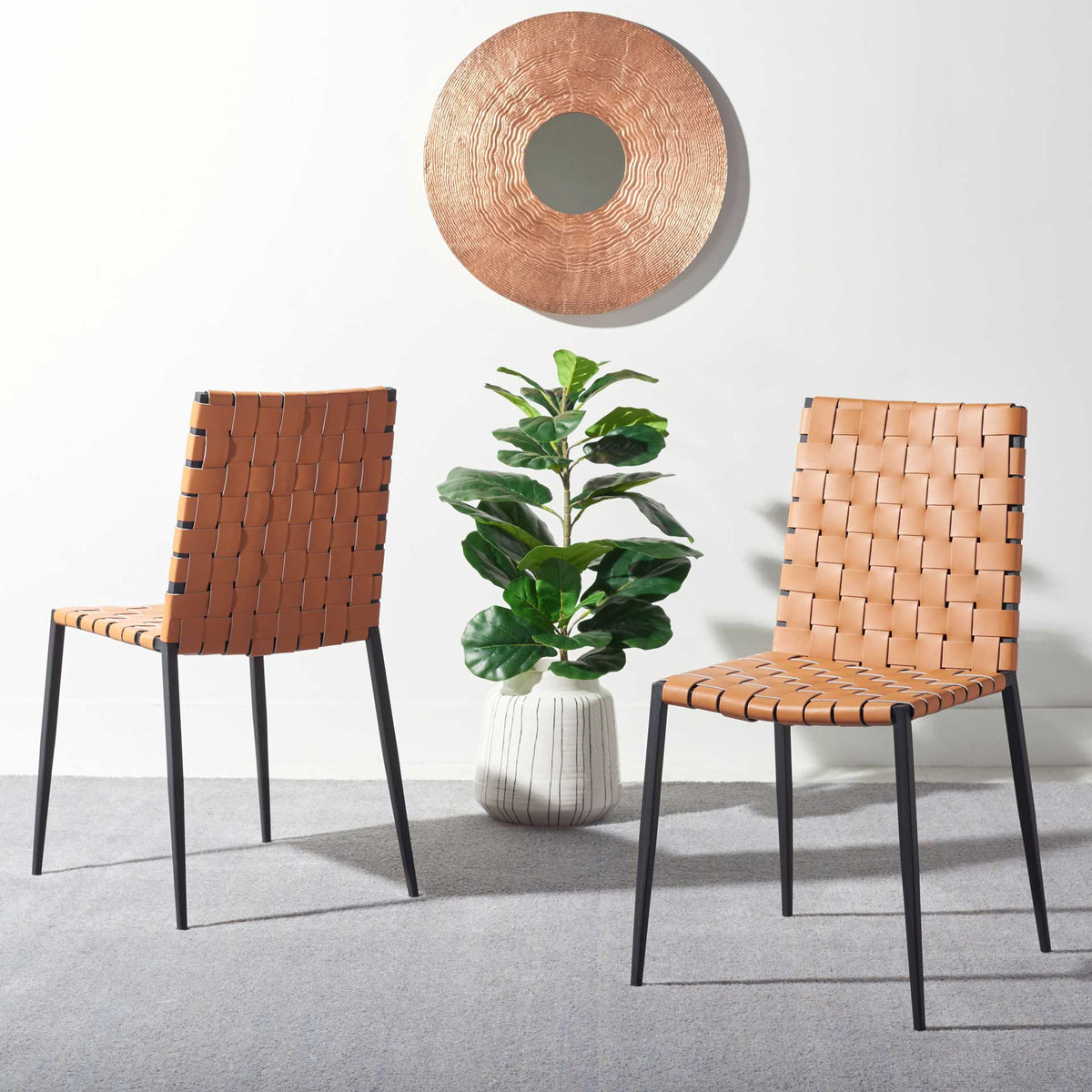 A matching pair of cognac woven chairs brings warmth and graphic black accents to a modern room.