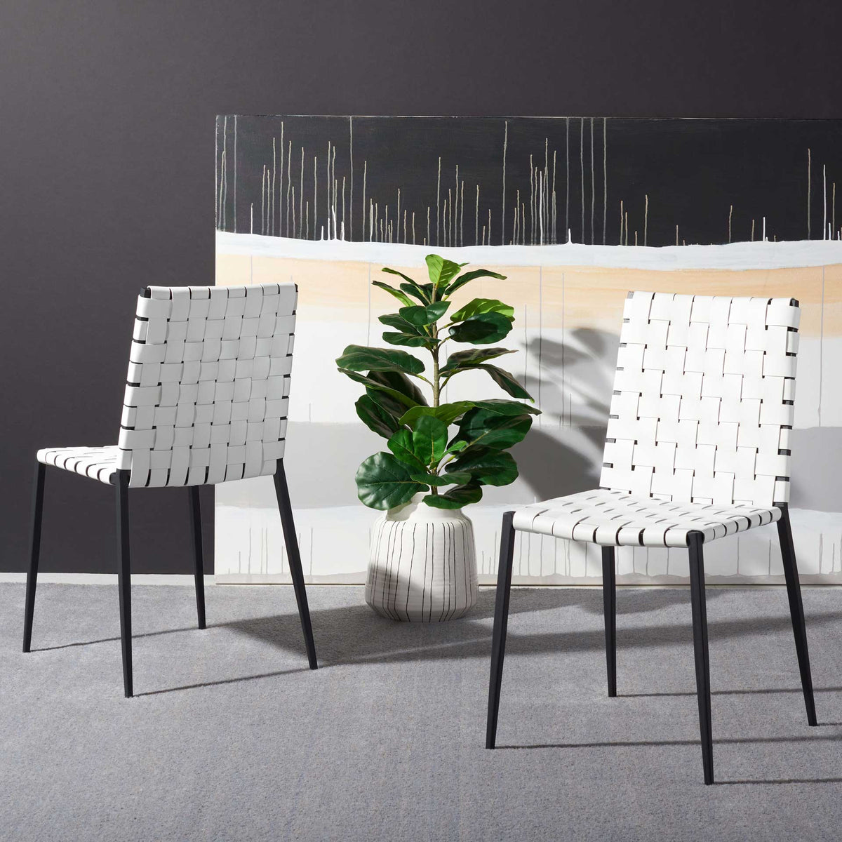 A matching pair of white woven chairs brings airy texture and bold black accents to the room.