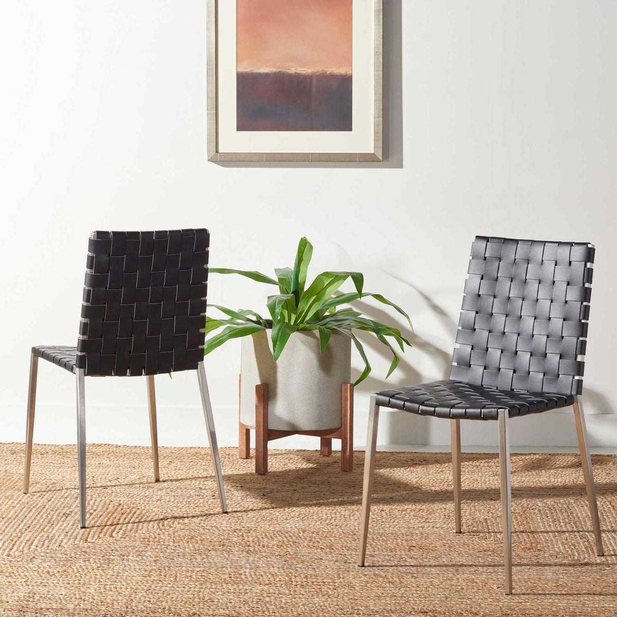 A pair of black woven chairs with silver legs adds modern contrast and texture to the room.