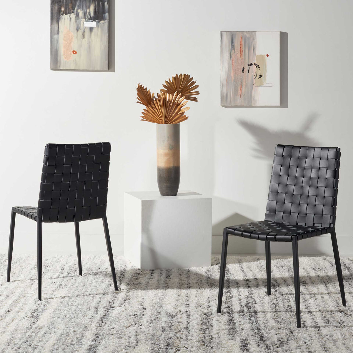 A pair of black woven dining chairs brings understated texture and slim-lined style to a modern room.