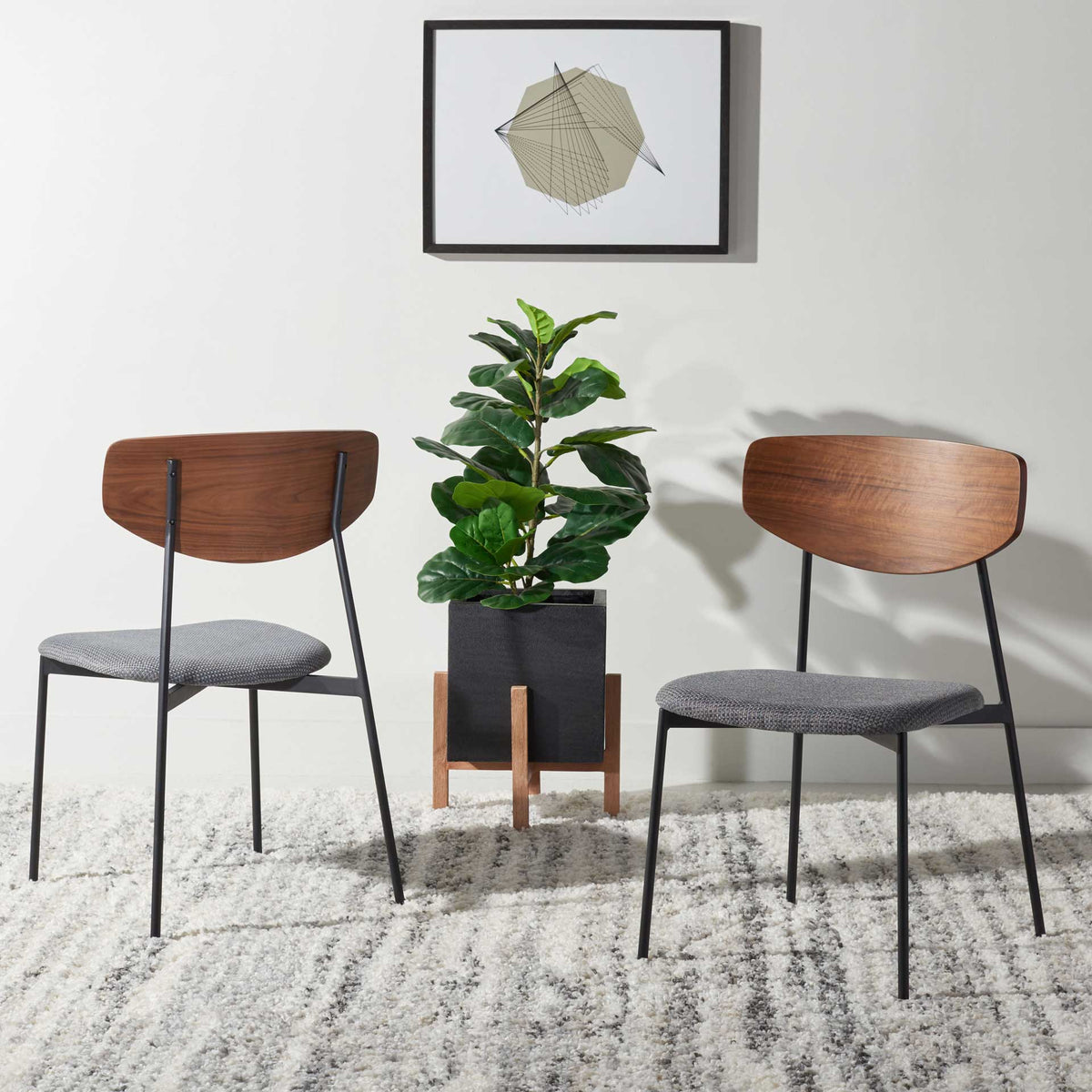 A pair of walnut-finished chairs brings gray cushioned seating and understated iron details to the room.