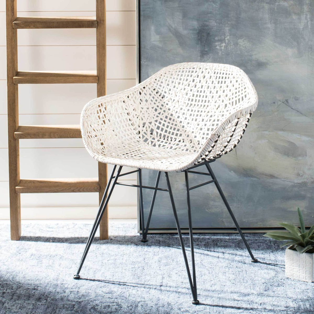 Airy white leather latticework creates a rounded seat atop slender dark gray metal legs
