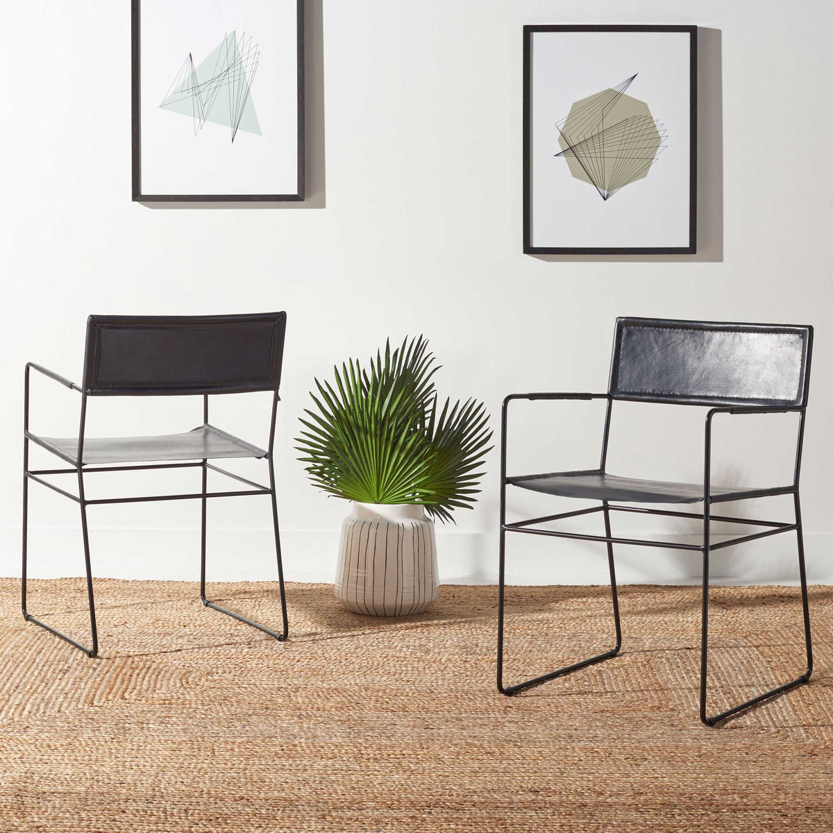 Two black leather dining chairs lend light, sculptural style to a modern dining area.