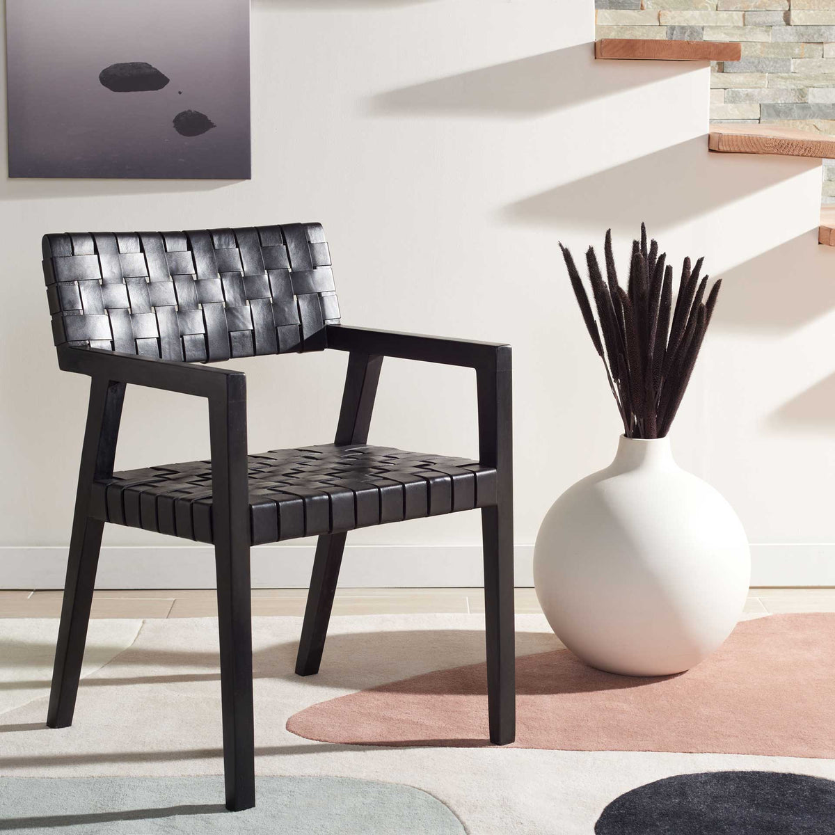 Black woven leather and angular wooden arms give this dining chair a bold modern look.