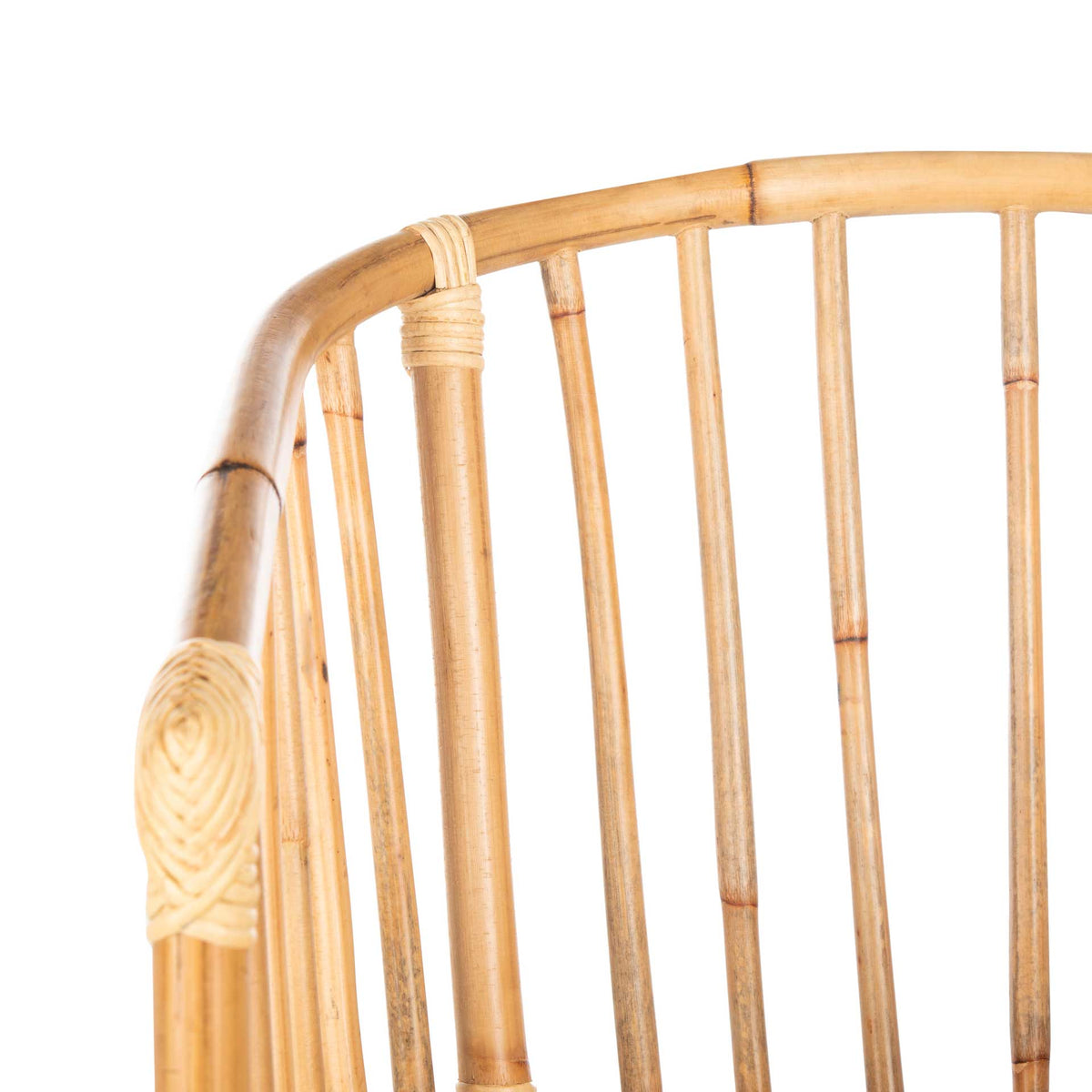 Smooth rattan rails, natural spindles, and woven bindings add texture to the curved back