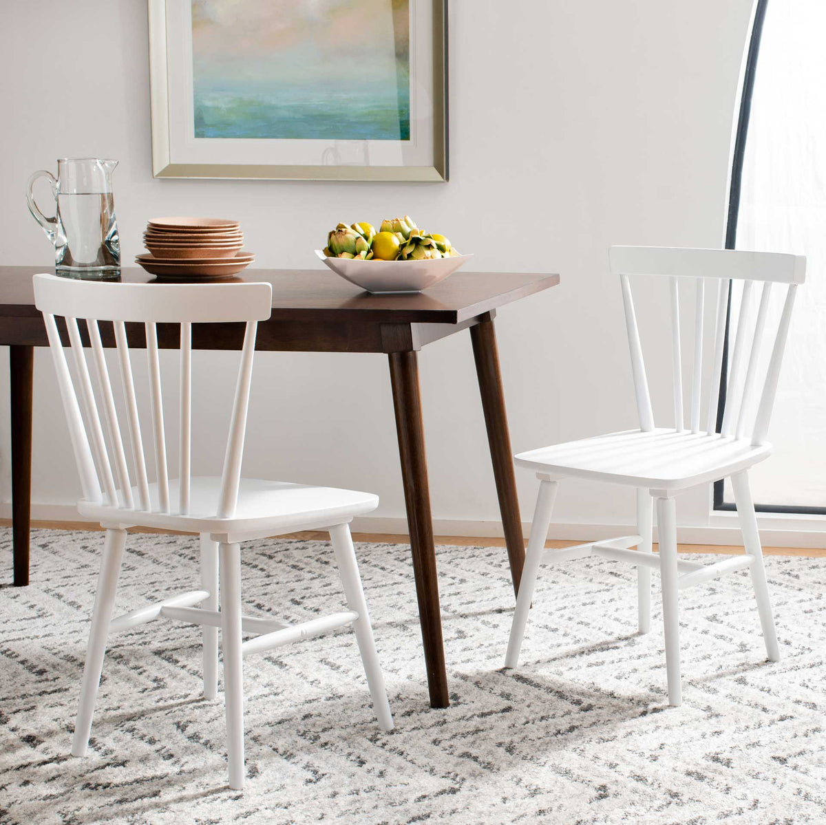 White rubberwood dining chairs frame a wooden table with curved backs and sturdy legs