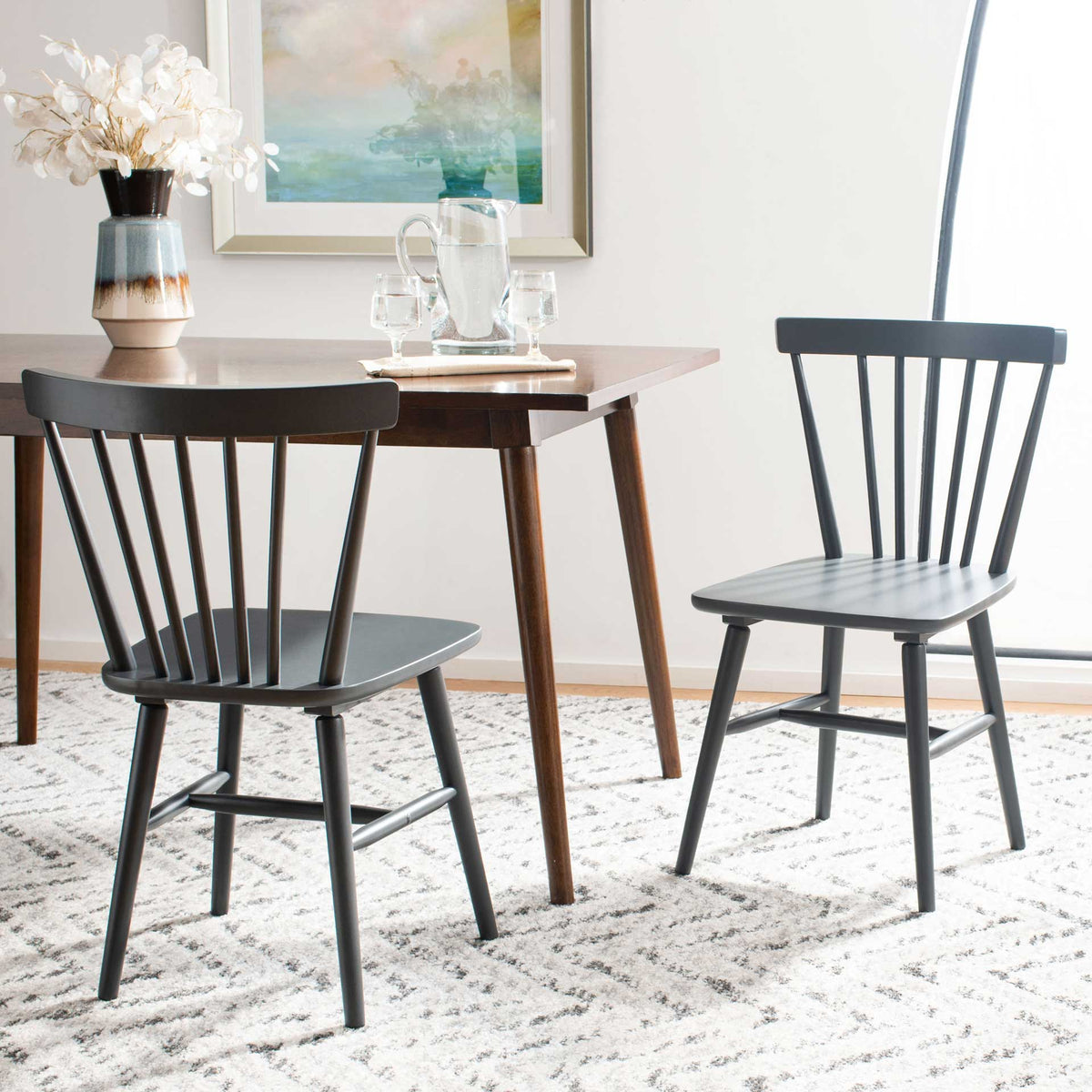 Gray wood dining chairs complement a warm dining table with their airy spindle backs