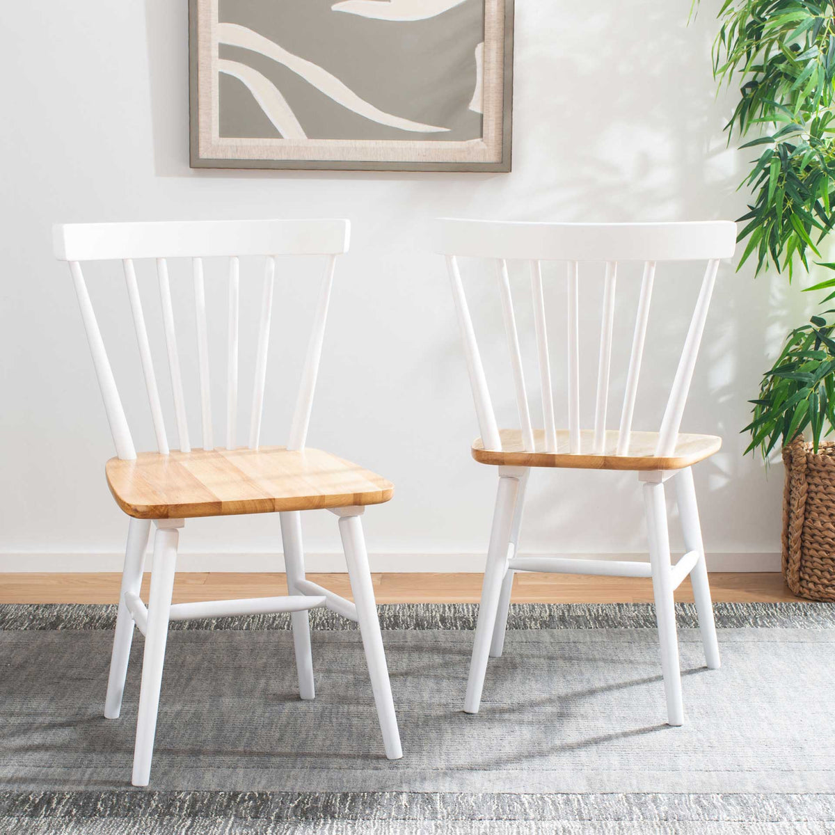 Two white chairs with natural wood seats bring airy farmhouse style to a bright room