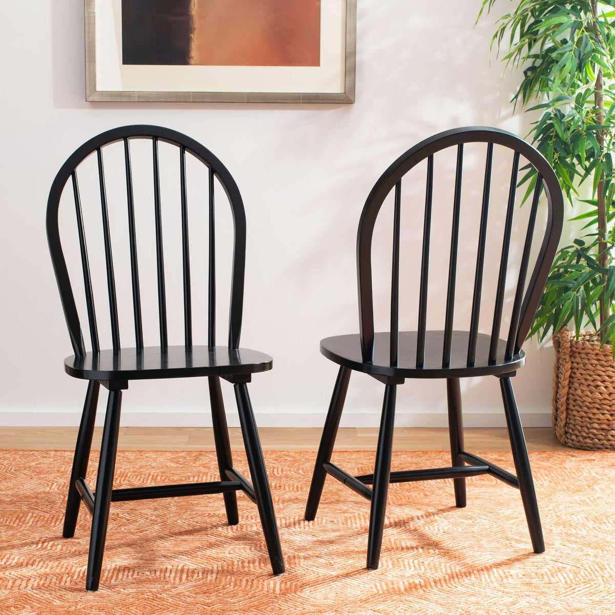 Two black spindle-back chairs add classic contrast with curved frames and solid wood seats