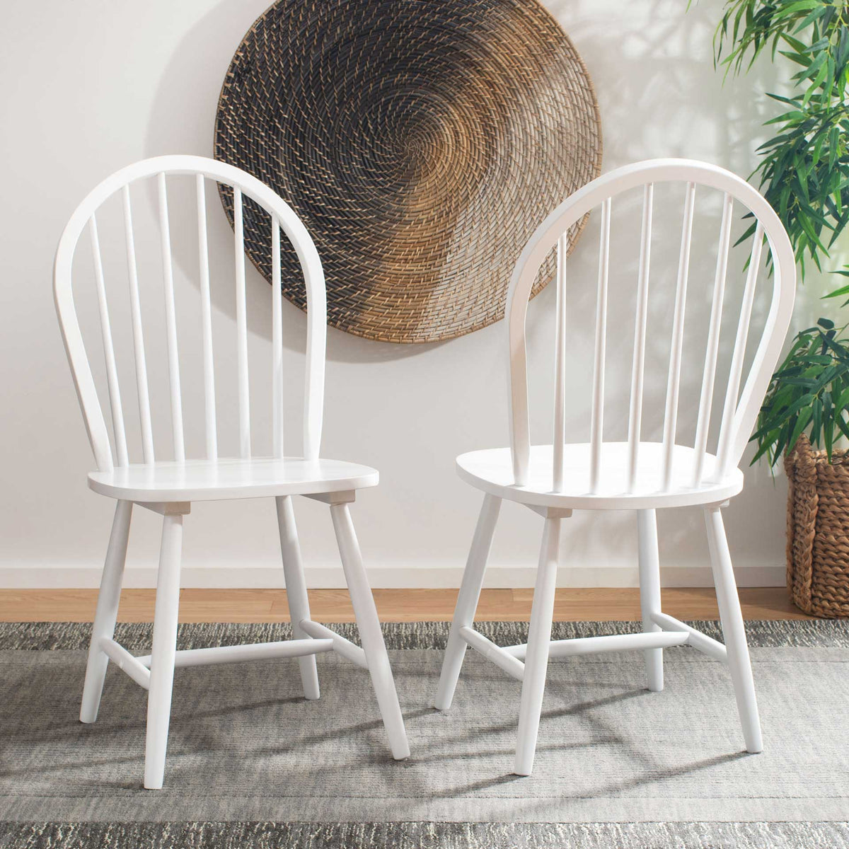 Two bright white dining chairs add airy spindle backs to a cozy dining area