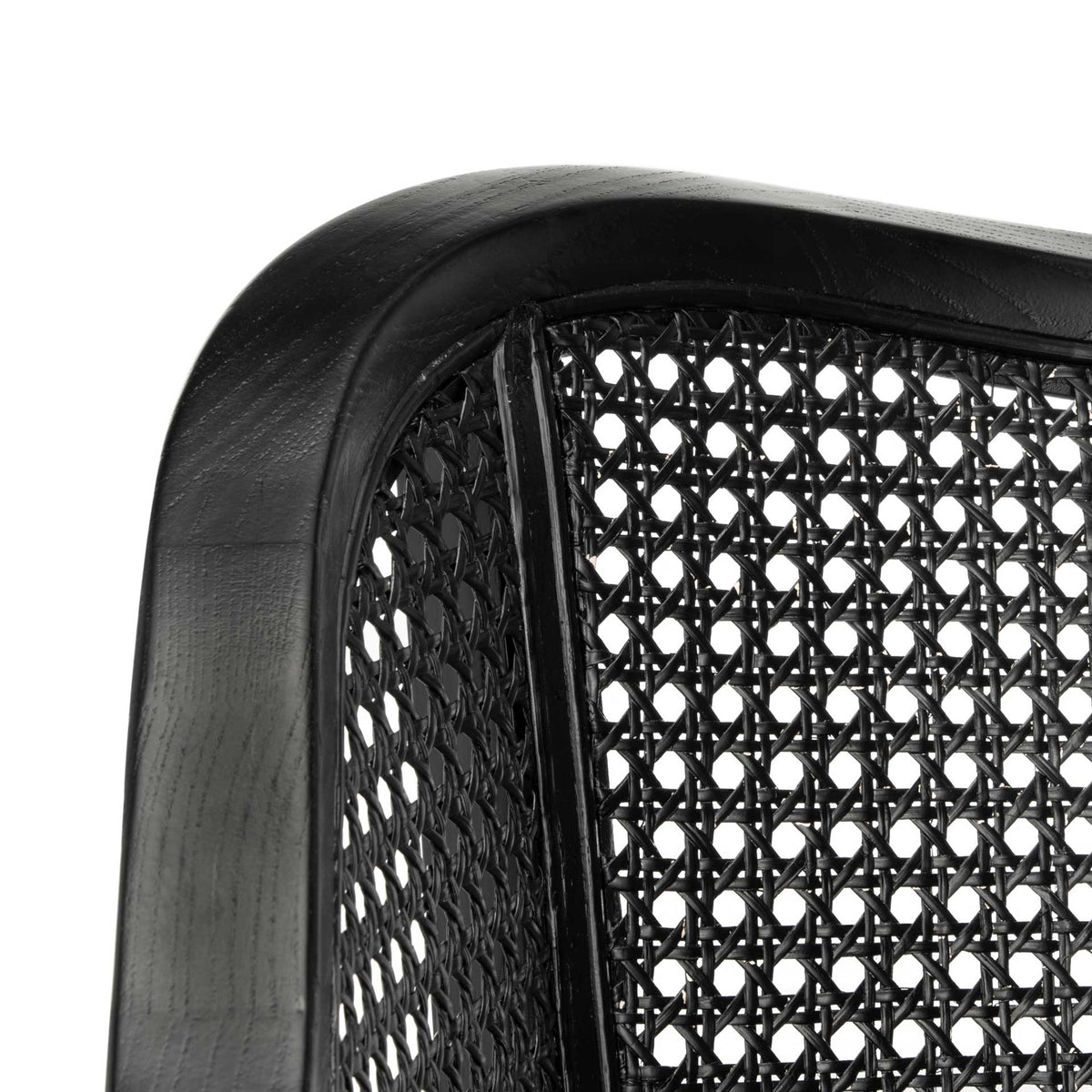 Intricate black cane weave meets the gently rounded edge of the painted wood frame