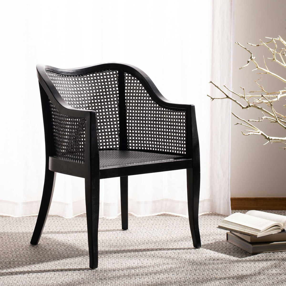 Black cane dining chair adds open-weave texture and sweeping lines to a softly lit interior