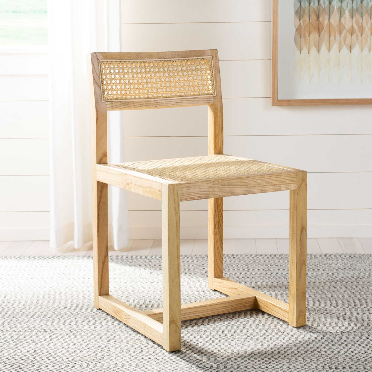 A natural elm dining chair with a woven cane seat and backrest warms a light-filled interior