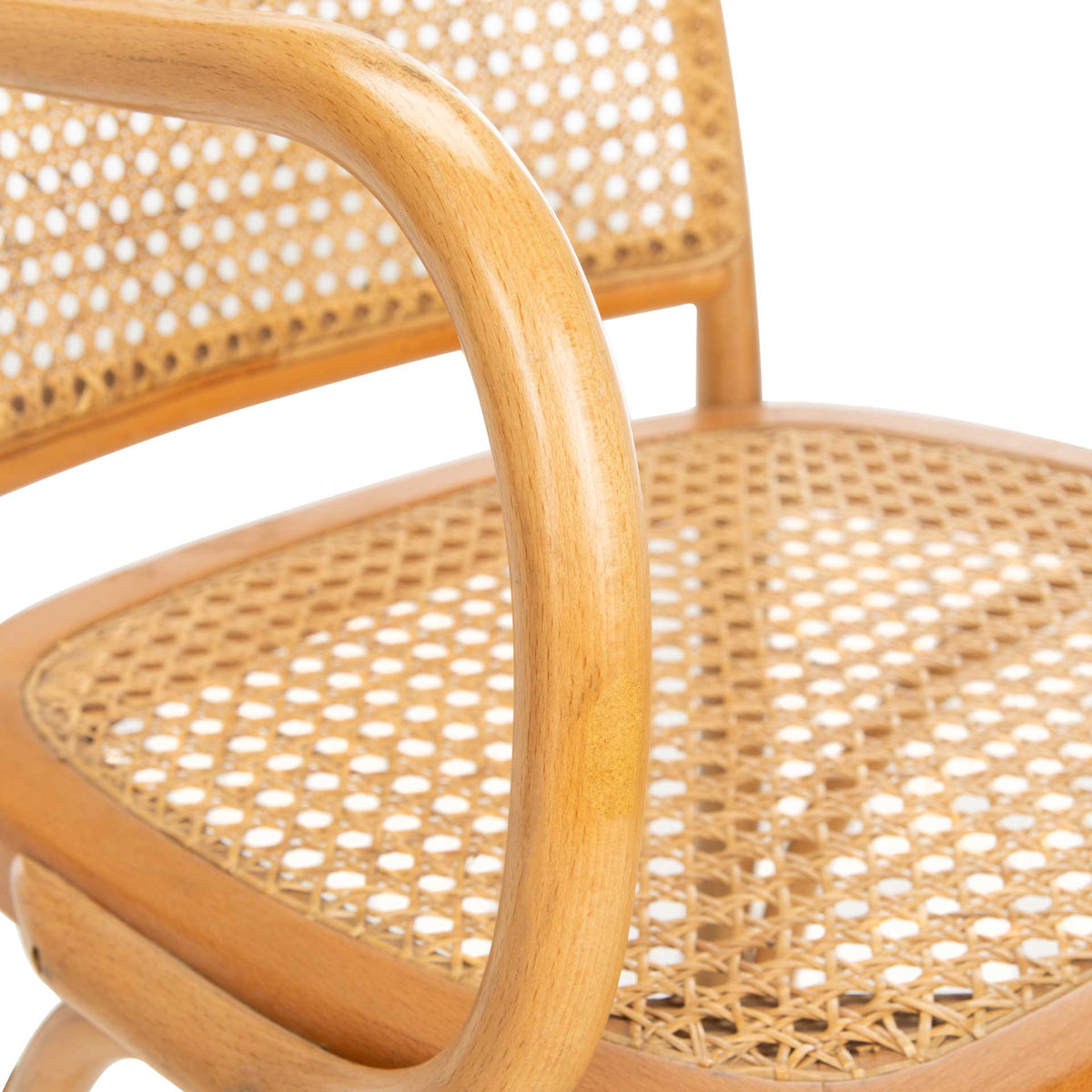 A smooth, curved natural wood armrest meets the airy cane weave of the seat and back.