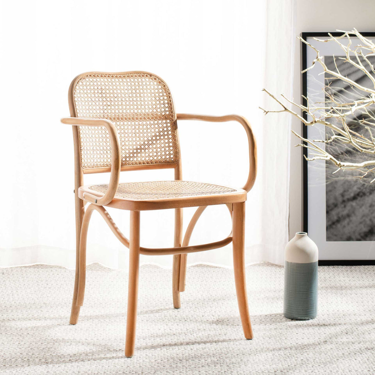 A natural wood frame and woven cane seat add warm, airy texture to a neutral space.