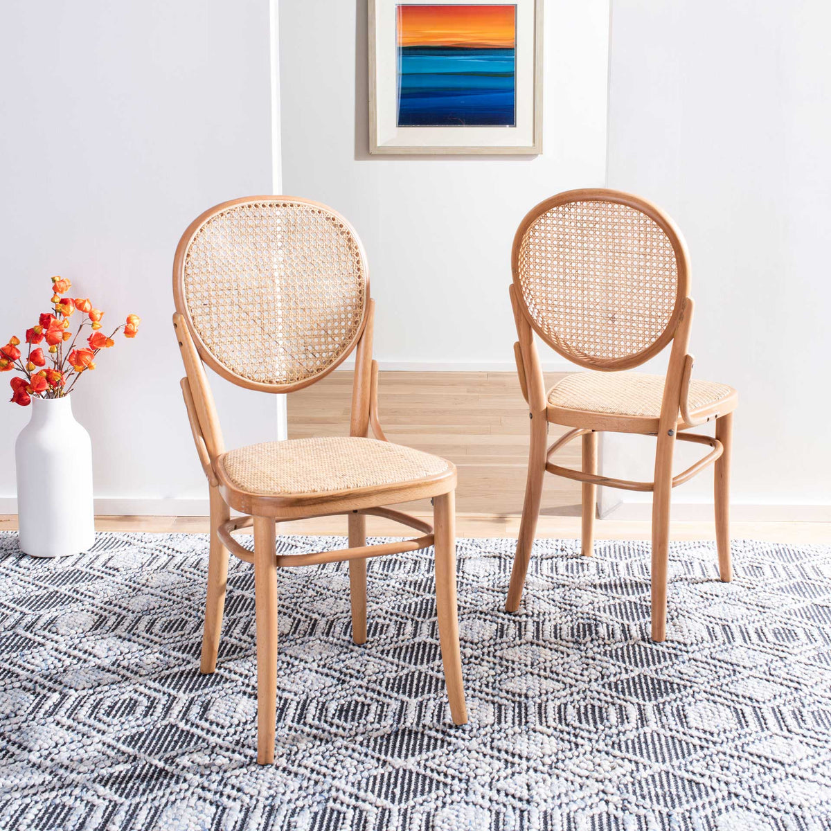 A pair of natural wood cane chairs adds warm woven texture and curved lines to a dining space.